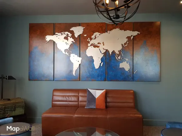 MapaWall Stainless Steel world map installed on a customized blue/brown panel, installed in a hotel lobby