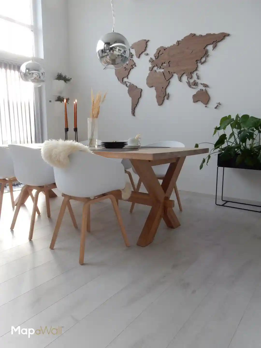 Magnetic MapaWall American Walnut world map with country border, untreated and installed in a modern Scandinavian interior in Norway.